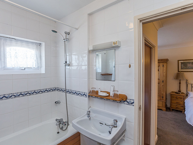 Ensuite bathroom with bath with shower over, basin and toilet