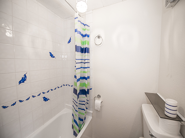 Bathroom - bath with shower over, toilet and basin