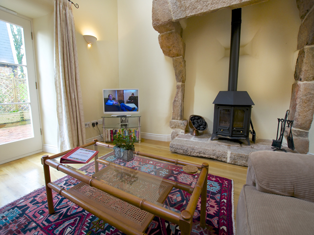 View of the wood burning stove in the lounge and doors to the patio