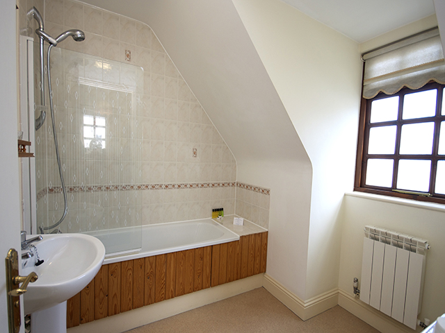 Bathroom with bath with shower over