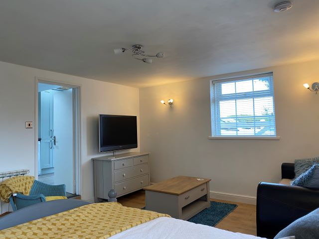 Open plan lounge and bedroom leading to kitchen