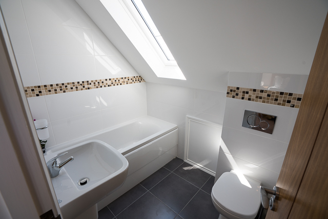 En-suite with shower over bath, sink and toilet