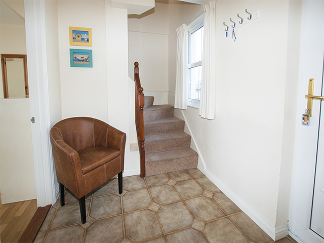 The entrance hall is on the ground floor, the bedrooms are on the beach side of this cottage