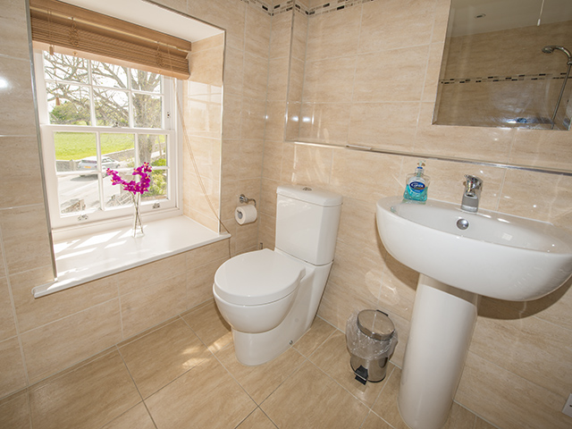 Spacious house bathroom with bath with shower over, basin and toilet