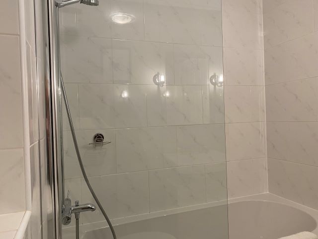 Bathroom with shower over bath, WC and basin