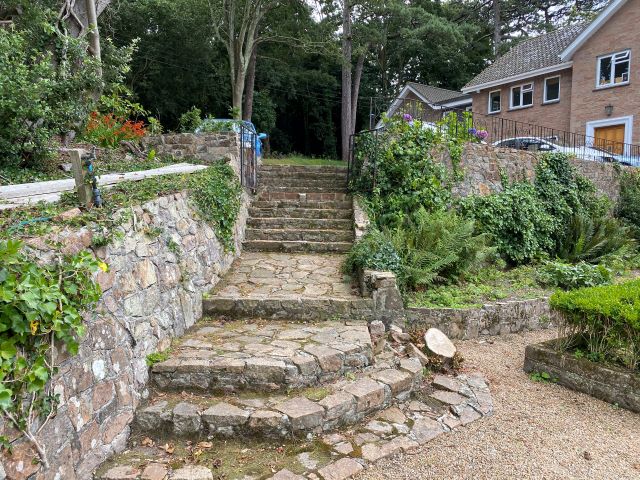 Stairs lead down to the extensive gardens and woodland areas
