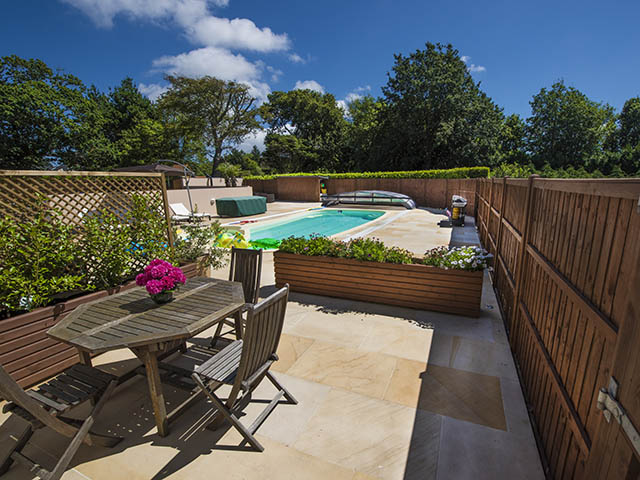 View over patio to shared outdoor pool beyond